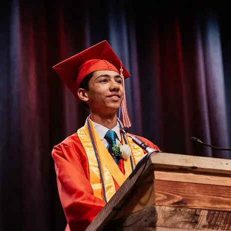 Estudiante graduado dando un discurso en su ceremonia de graduación